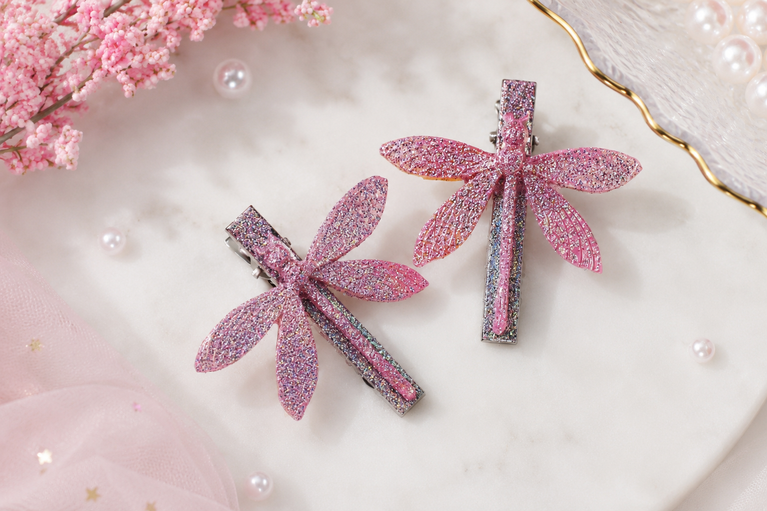 The image shows two pink dragonfly hair clips