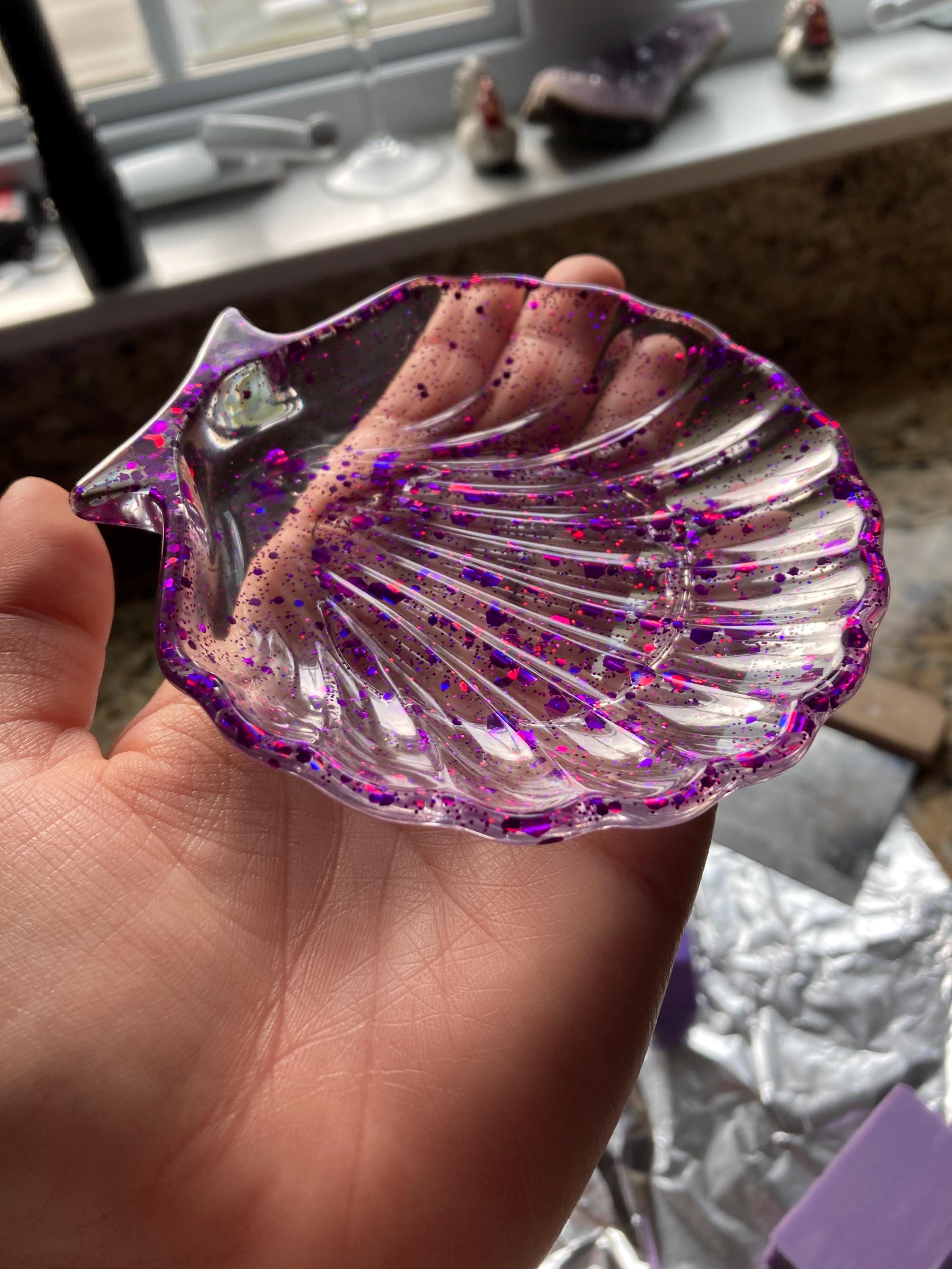 Hand holding a purple sequin soap dish
