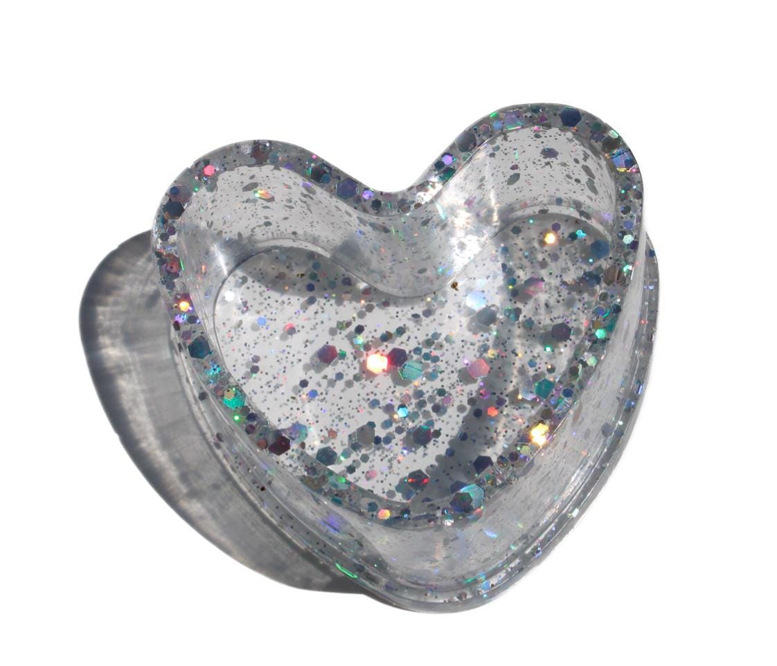Heart-shaped ring dish with glittery finish on a white background