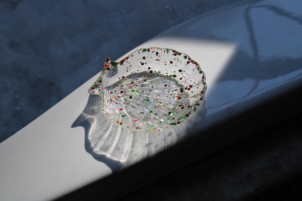 Decorative shell with colorful beads on a metallic surface