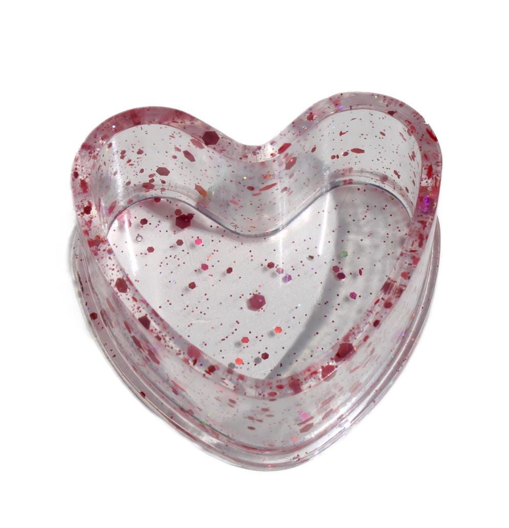 Heart-shaped dish with pink speckles on a white background