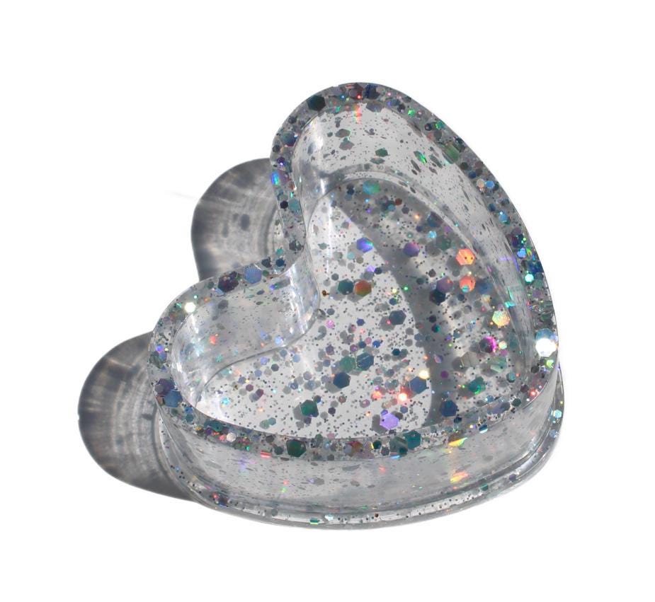 Heart-shaped ring dish with glittery finish on a white background
