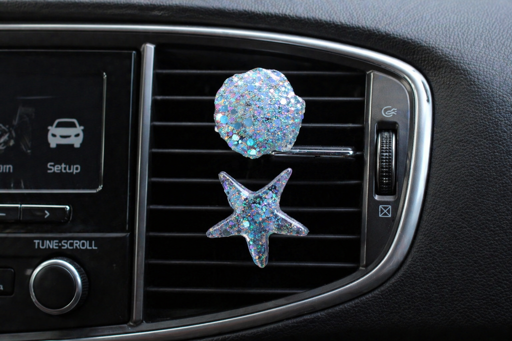 Car vent clips with starfish and shell design on a car vent.