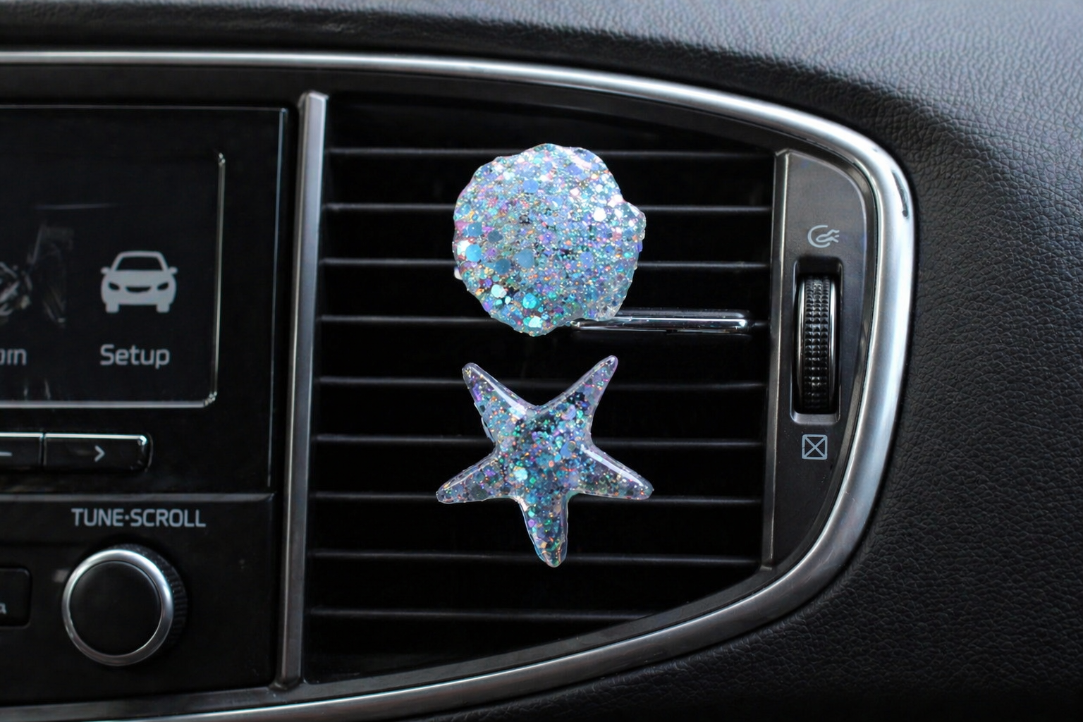 Car vent clips with starfish and shell design on a car vent.