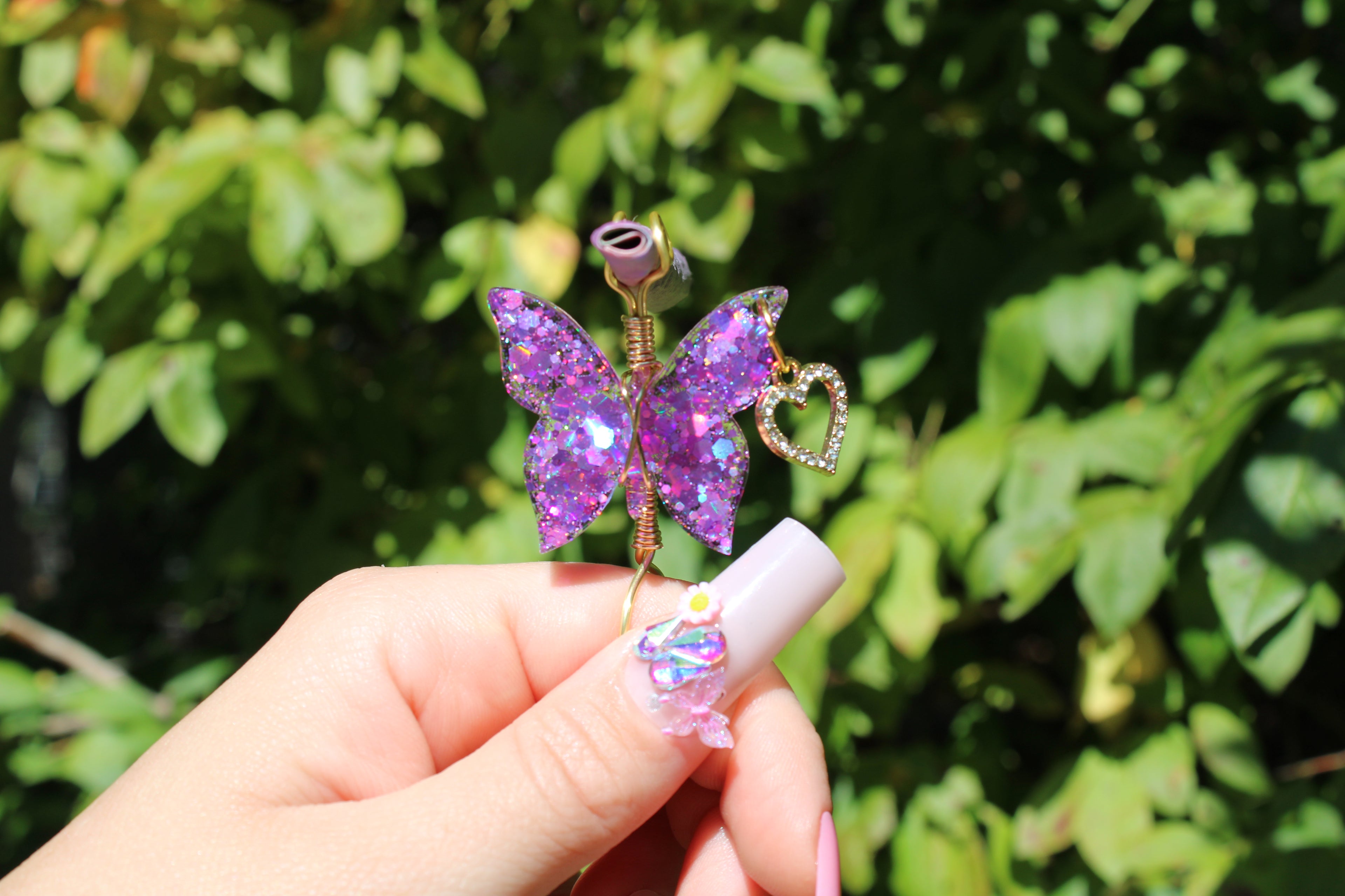 Purple Butterfly Smoke Ring Held Infront Of A Bush