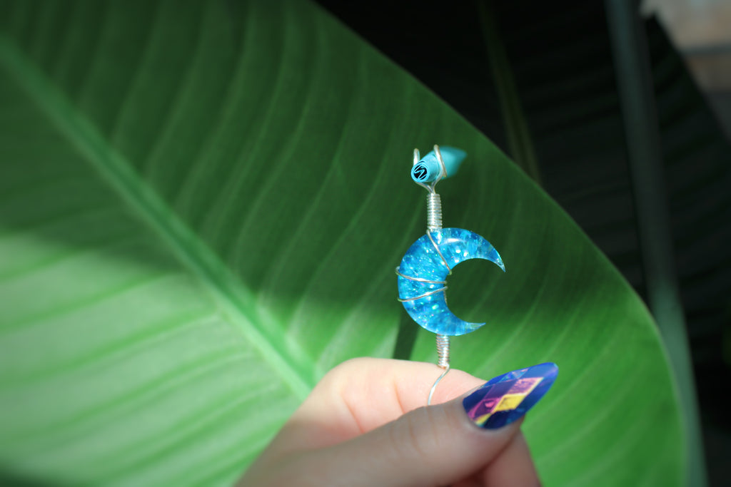 Blue moon smoke ring held against a green leaf background