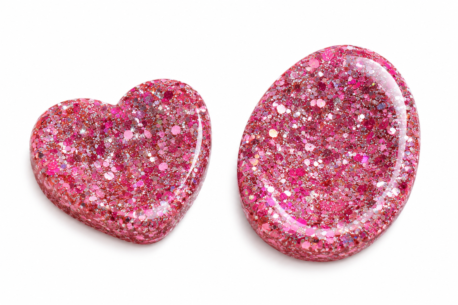 Two pink glitter resin anxiety tokens, one heart-shaped and one oval, displayed on a clean white background.