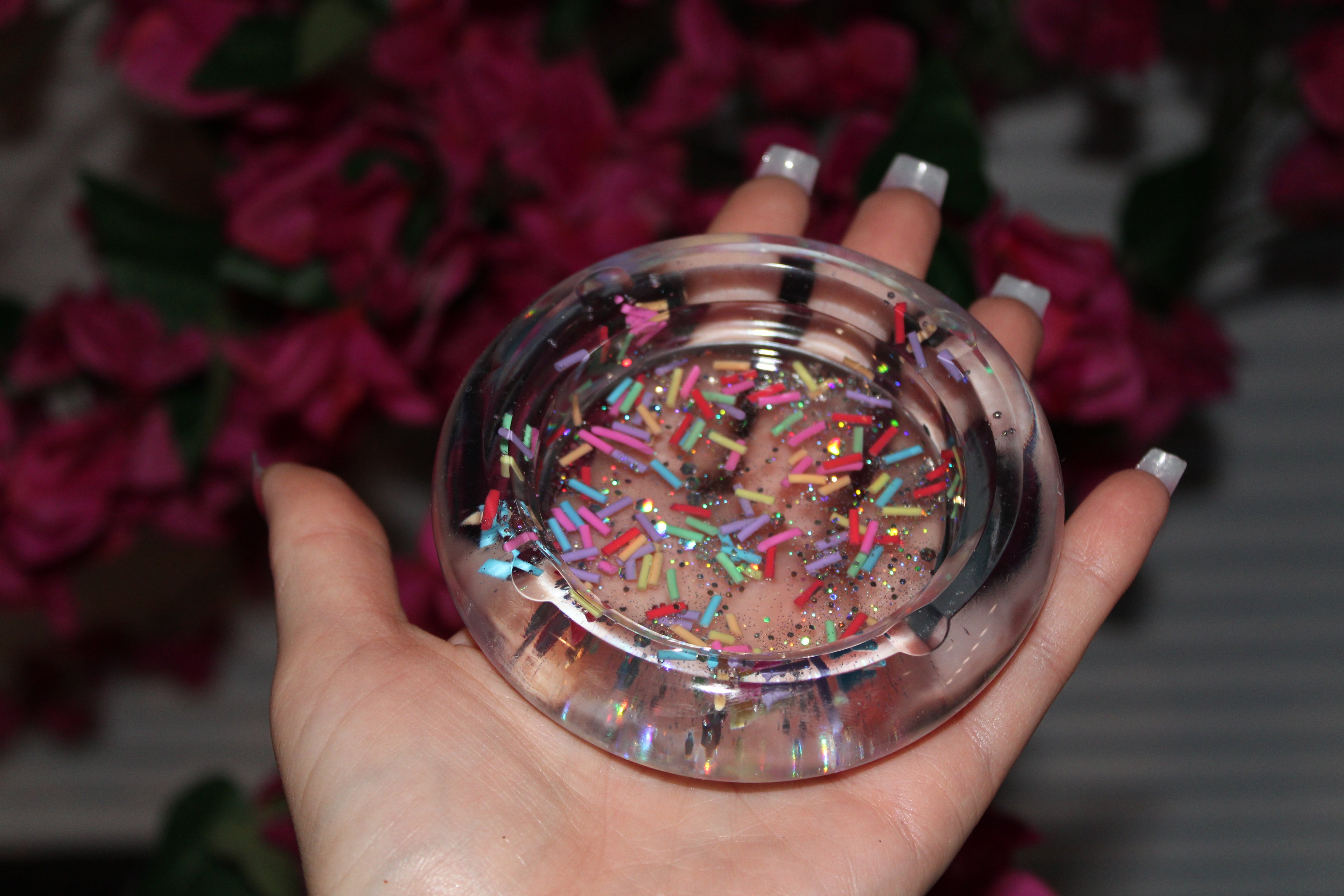 Resin ashtray with sprinkles held by a hand.