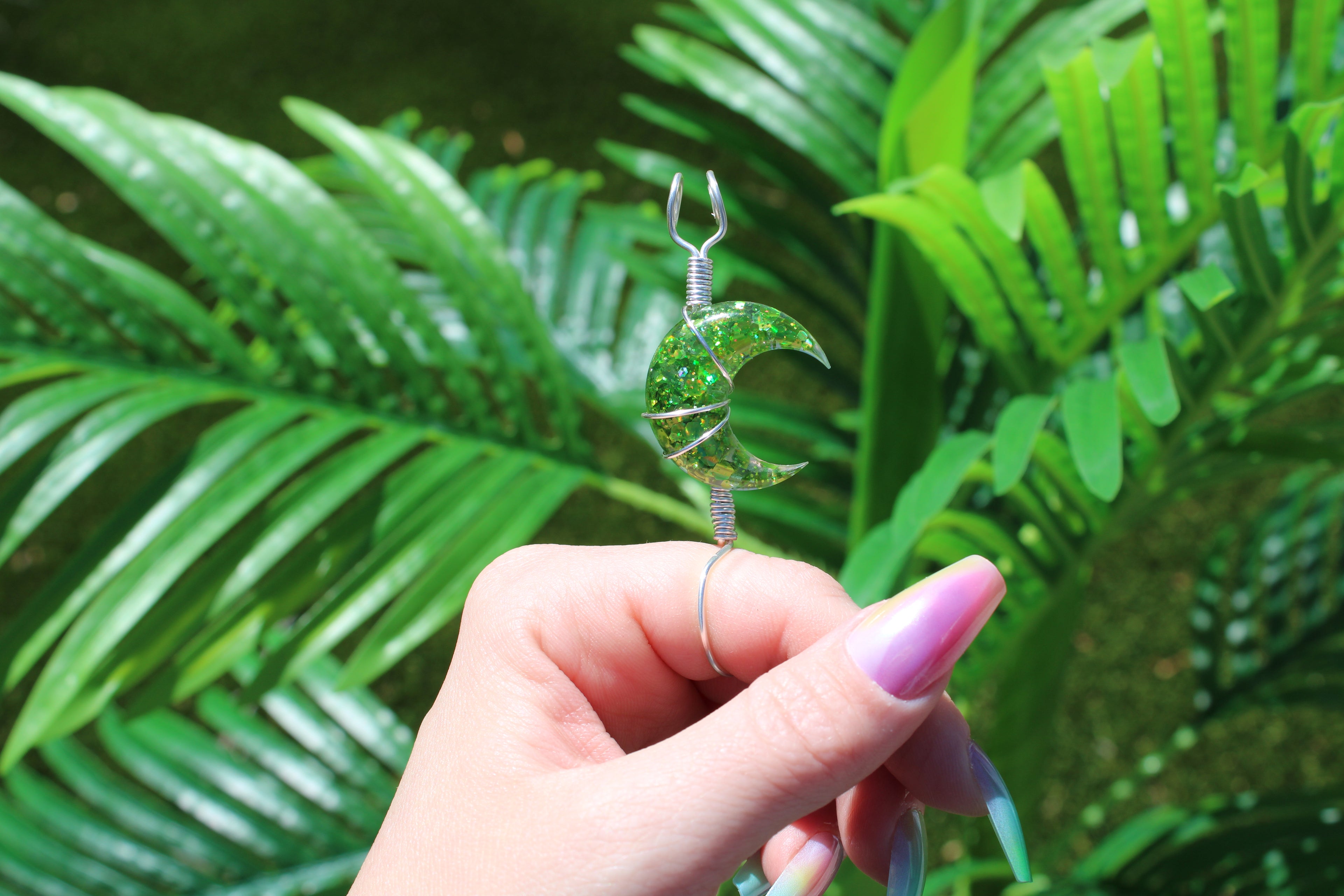Hand holding a green crescent moon smoke ring