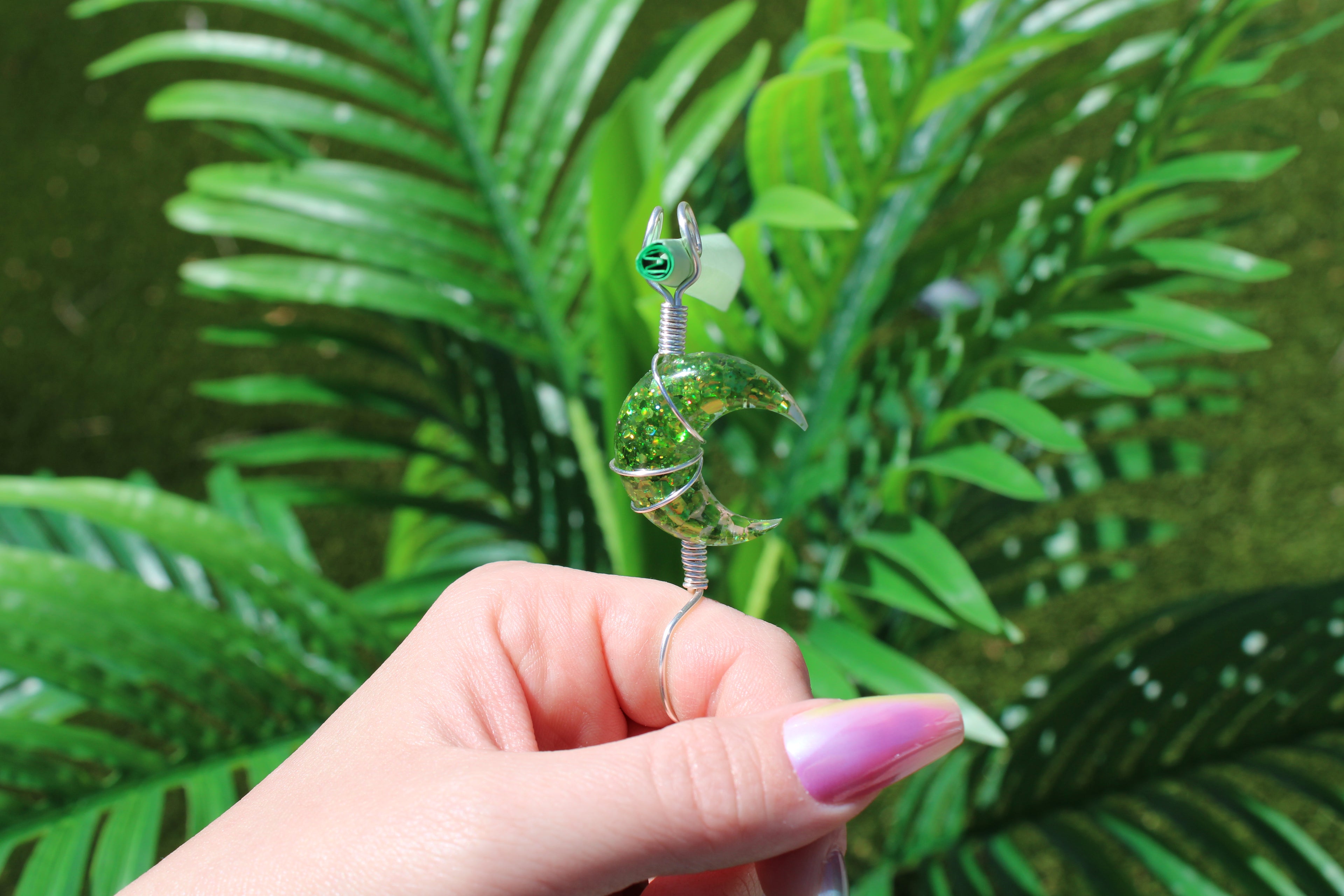 Hand holding a green crescent moon smoke ring 