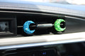 Car vent clips with blue and green crescent moon designs on a car dashboard.