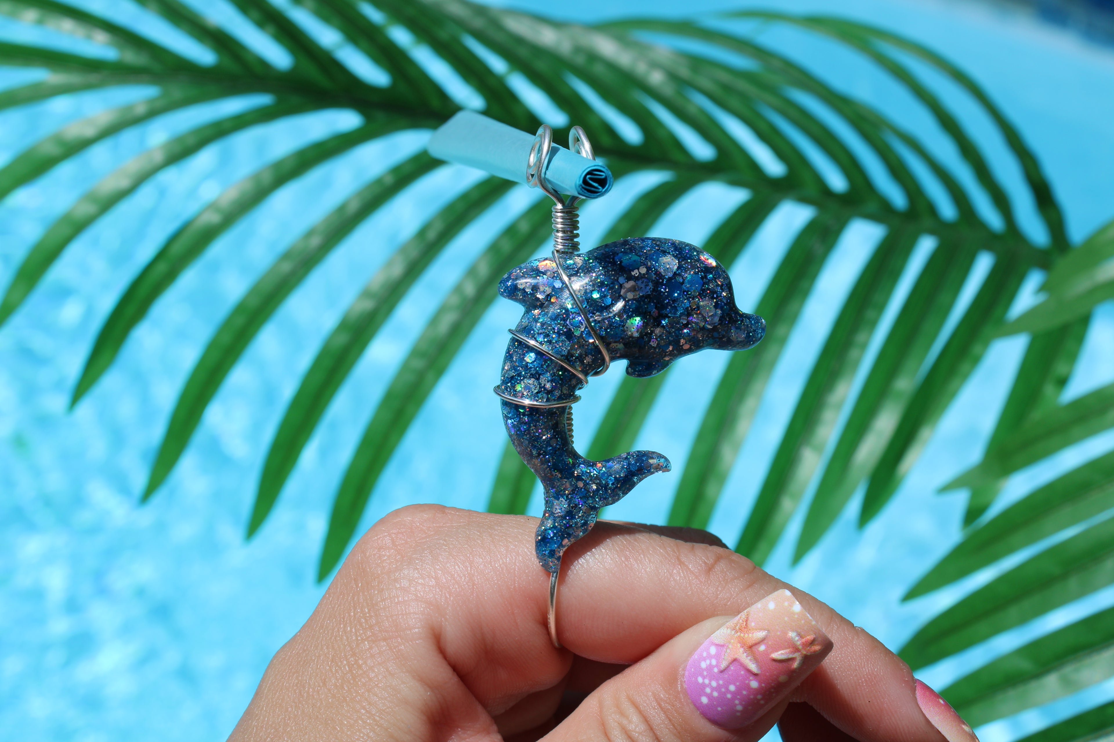 Blue dolphin smoke ring in front of a pool