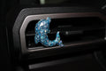 Decorative blue glittery dolphin car decor on a car vent.