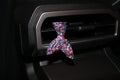 Multicolored car vent clip shaped like a mermaid tail on a car vent.