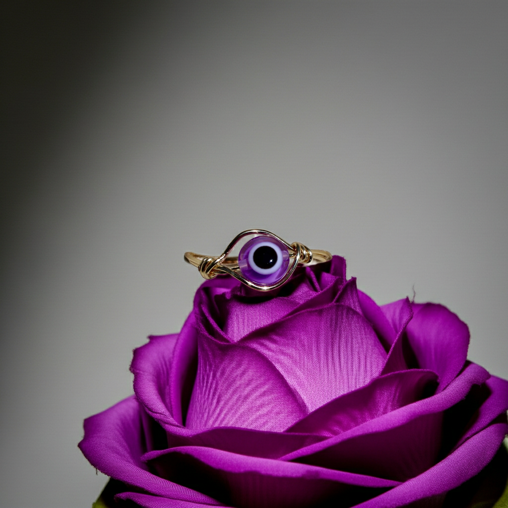 Purple evil eye ring rests on a purple flower