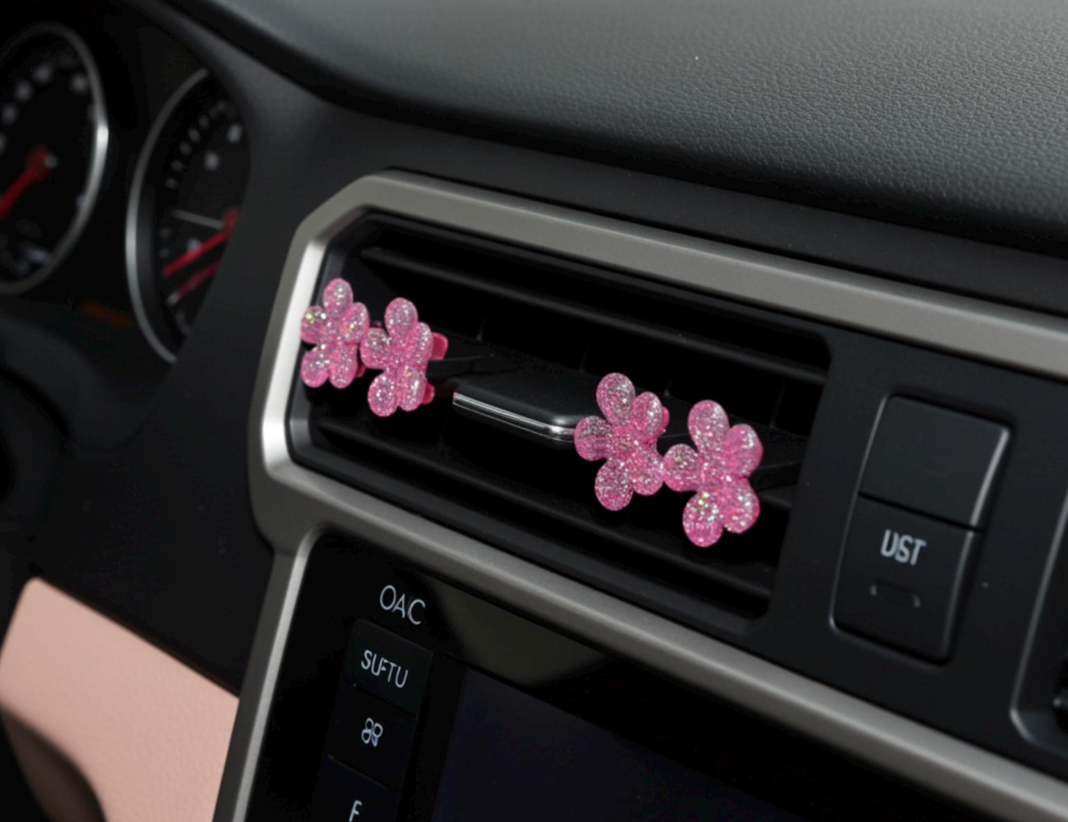 Pink floral car decor in a car's air vent.