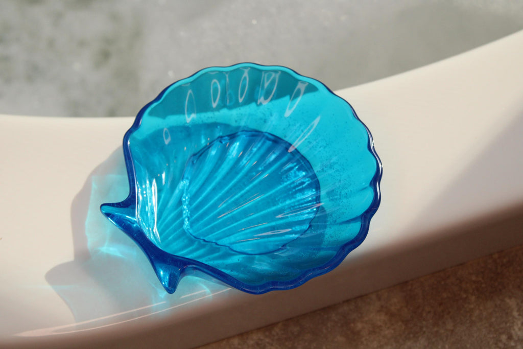 Blue shell-shaped soap dish on a white surface