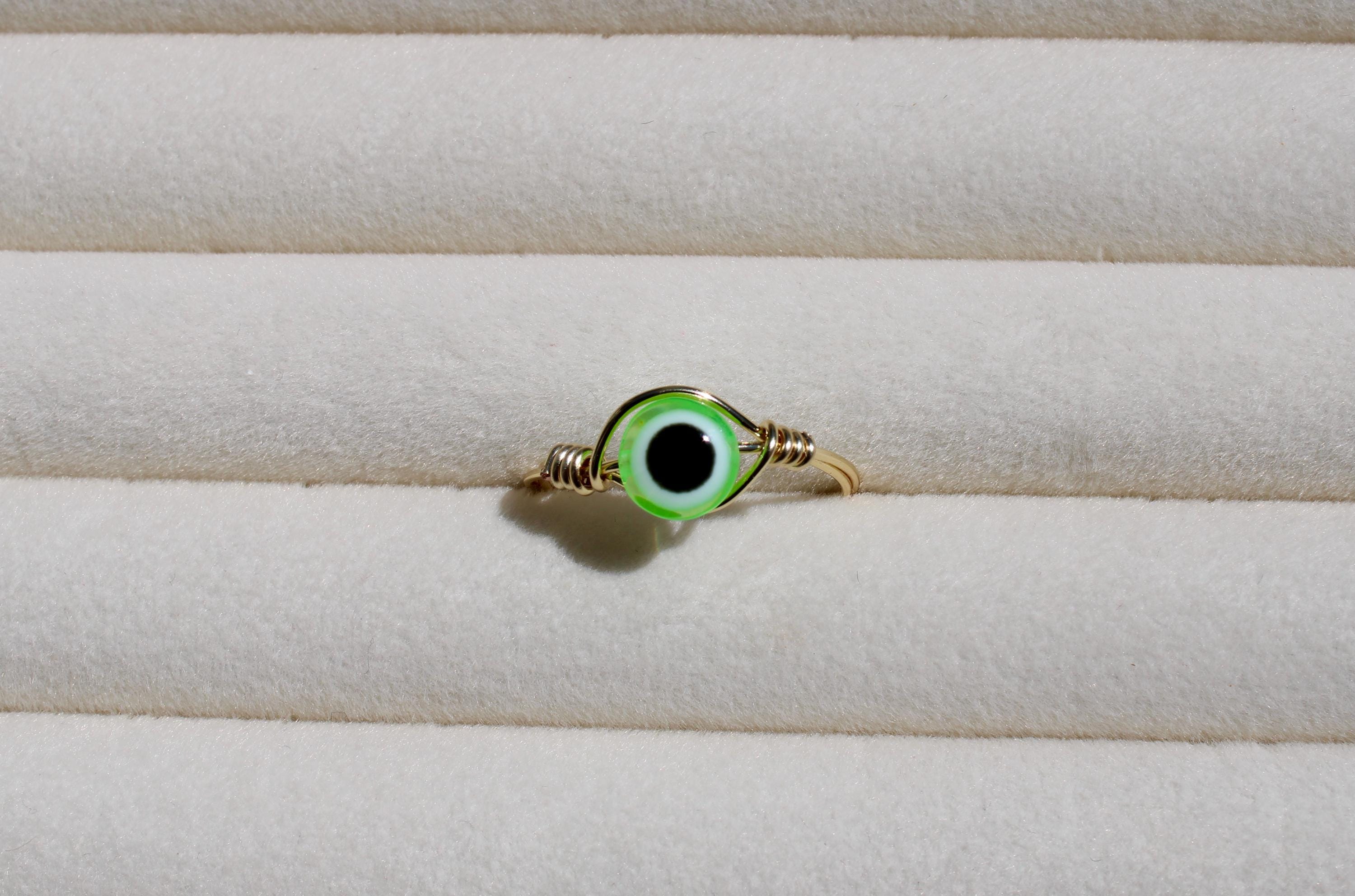 Ring with green eye design on a white background