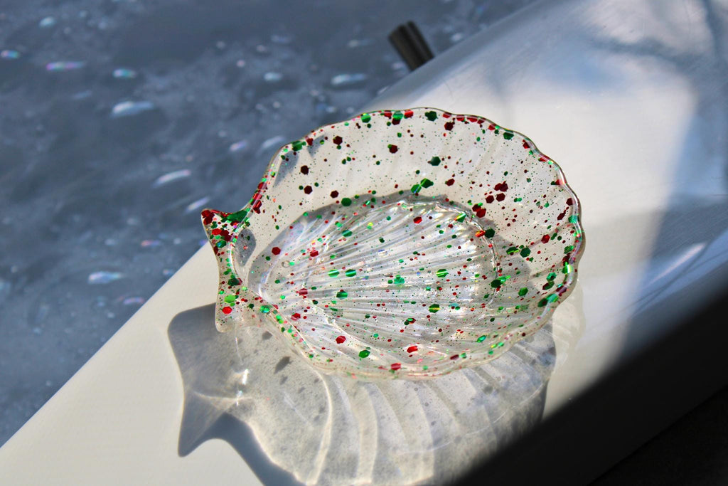 Decorative resin shell with colorful speckles on a reflective surface