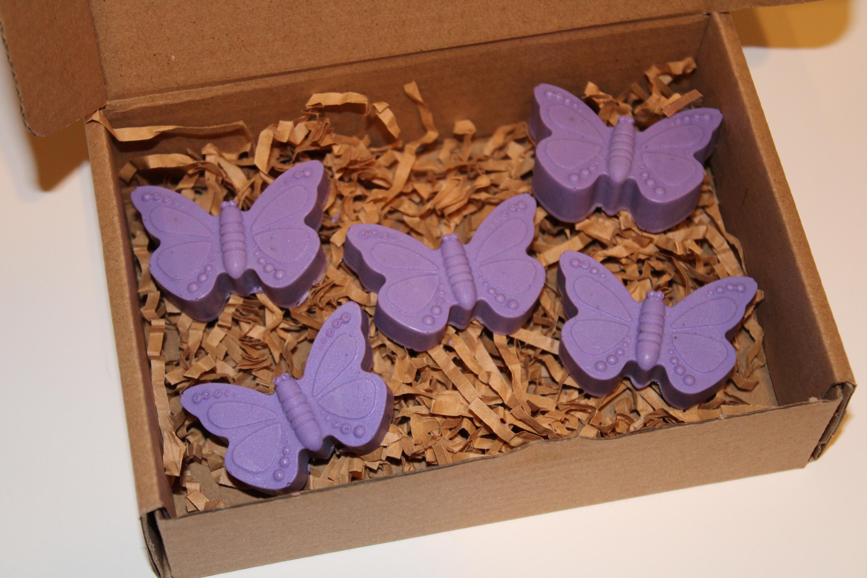 Purple butterfly-shaped objects in a box with brown packing material