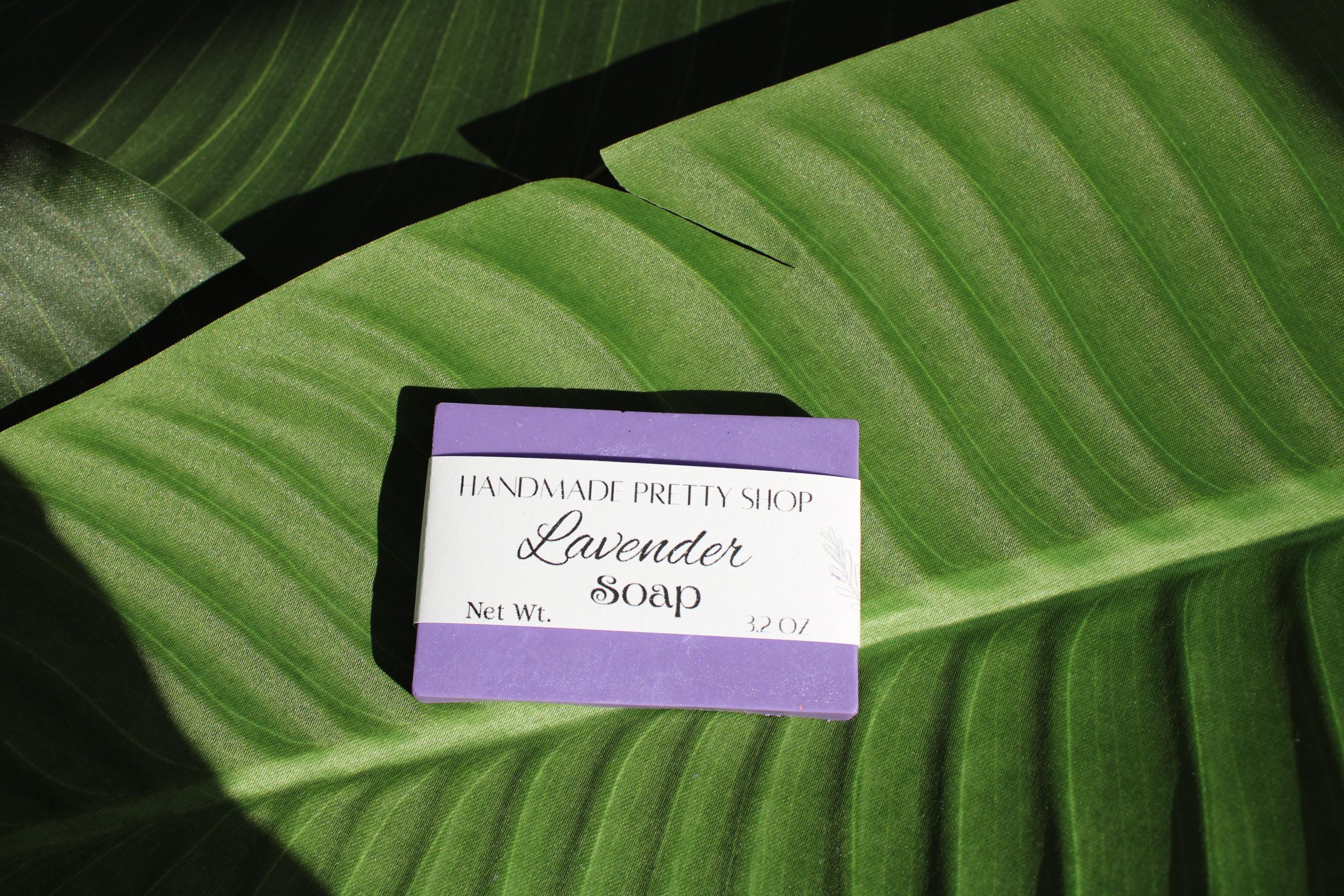 Handmade lavender soap bar with a label on a large green leaf