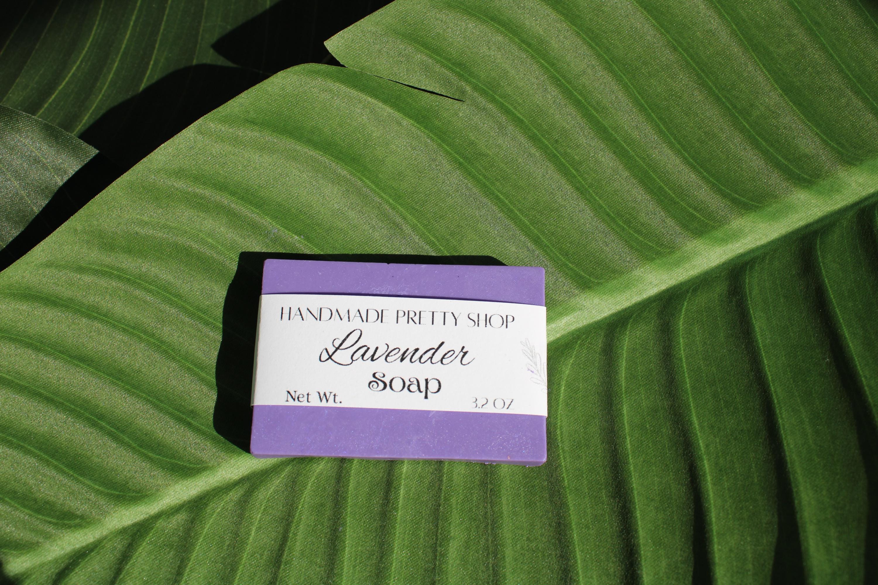 Bar of lavender soap with a purple label on a green leaf