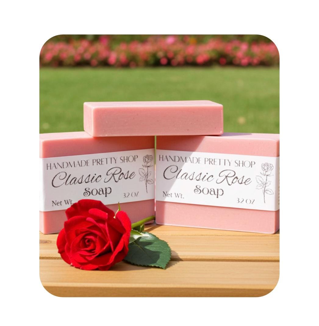 Two bars of pink 'Classic Rose Soap' with a red rose on a wooden surface, outdoors.
