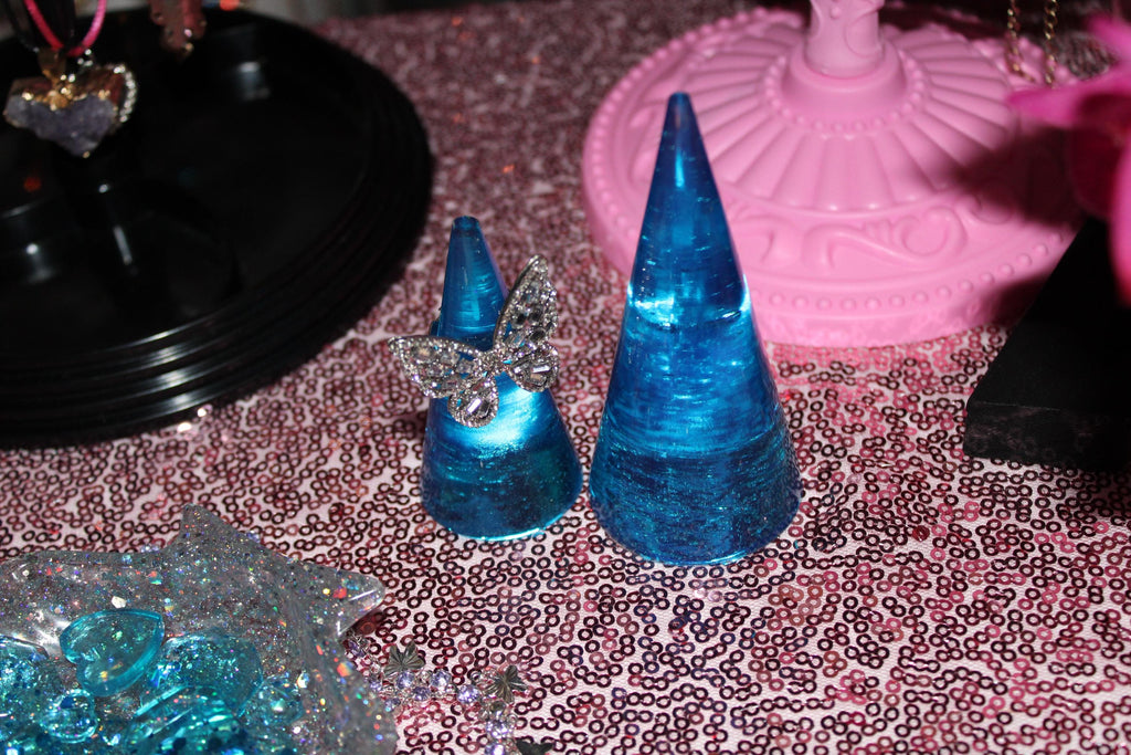 Blue jewelry cone display on a patterned surface.