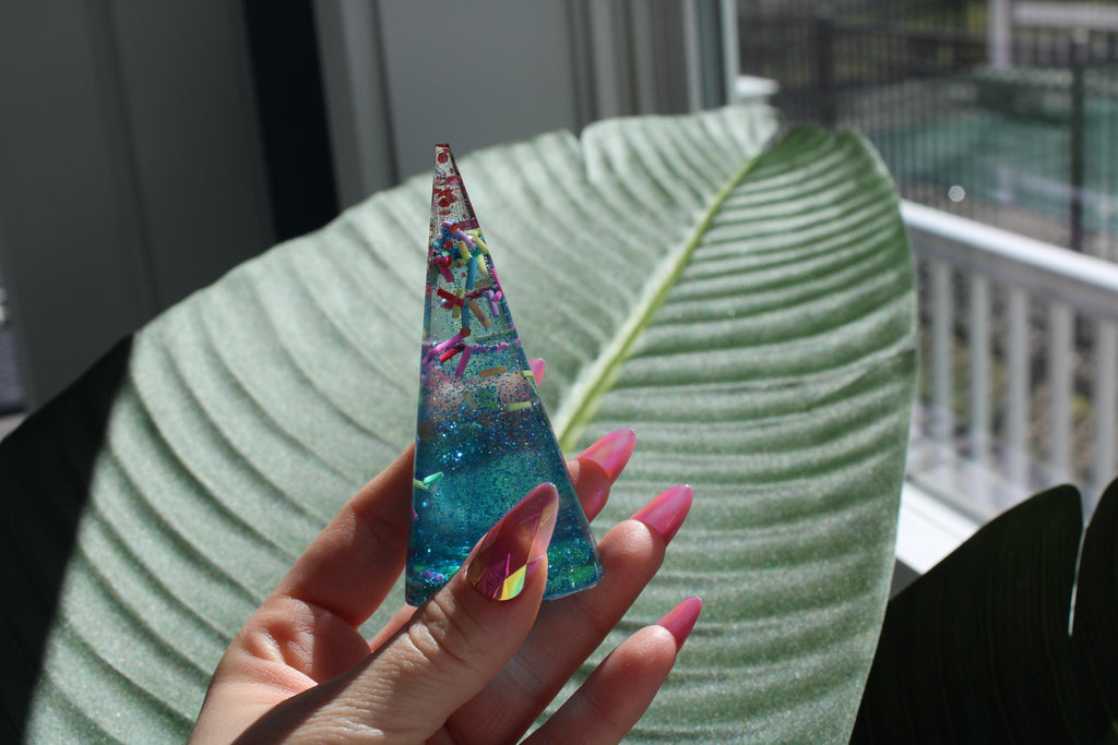Sprinkle design ring cone holder held by a hand against a leafy background
