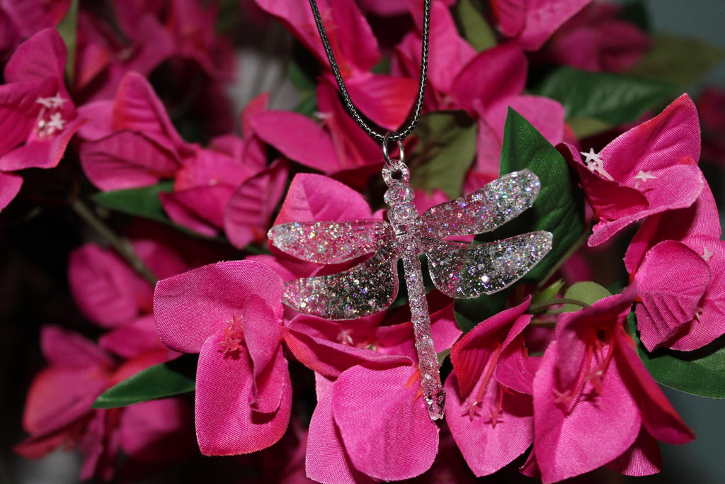 Dragonfly-shaped necklace on pink flowers