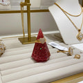 Pink glittery ring holder display cone on a jewelry display with gold necklaces and rings.