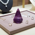Purple glittery ring display cone on a jewelry display with rings and necklaces