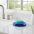 Blue soap dish on a kitchen sink with a window in the background