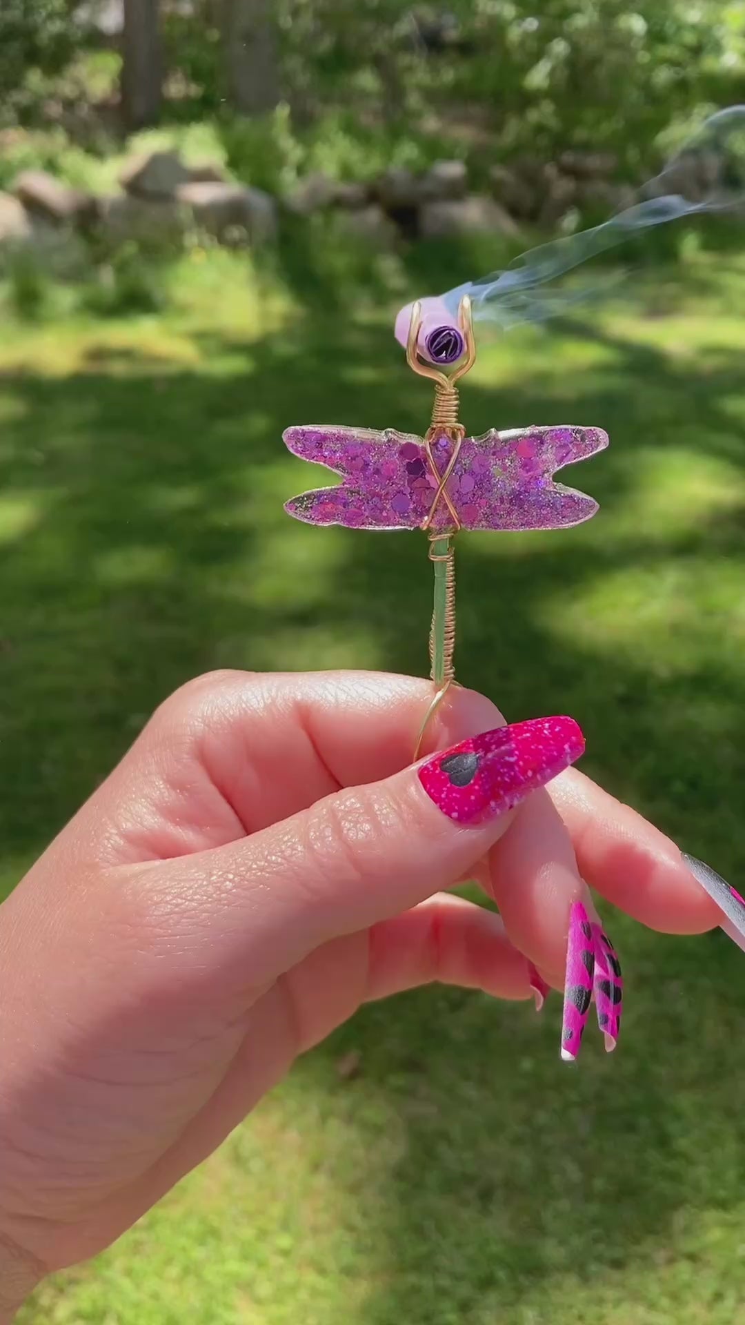 Video shows a purple sequin dragonfly smoke ring lit with a faux joint outside 