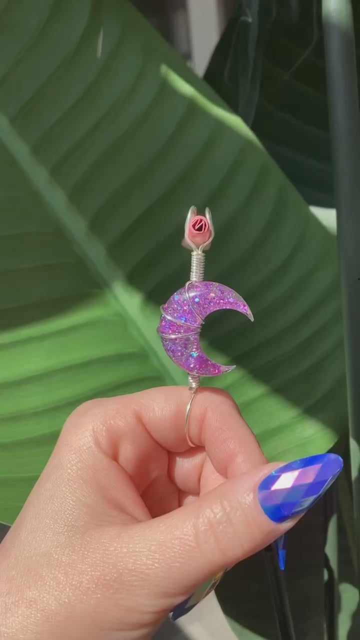 Video shows a purple sequin crescent moon smoke ring lit with a faux joint in front of a fake plant 