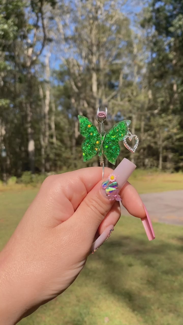 Green butterfly smoke ring with a lit faux joint in a nature setting 