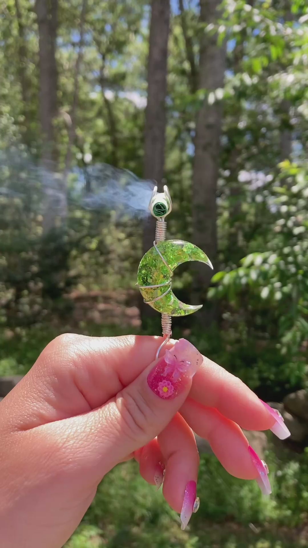 Video shows a green sequin moon smoke ring lit with a faux joint outside 