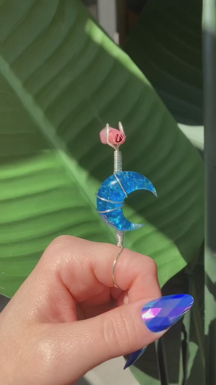 Video shows a blue moon smoke ring held by a manicured hand with a leafy background