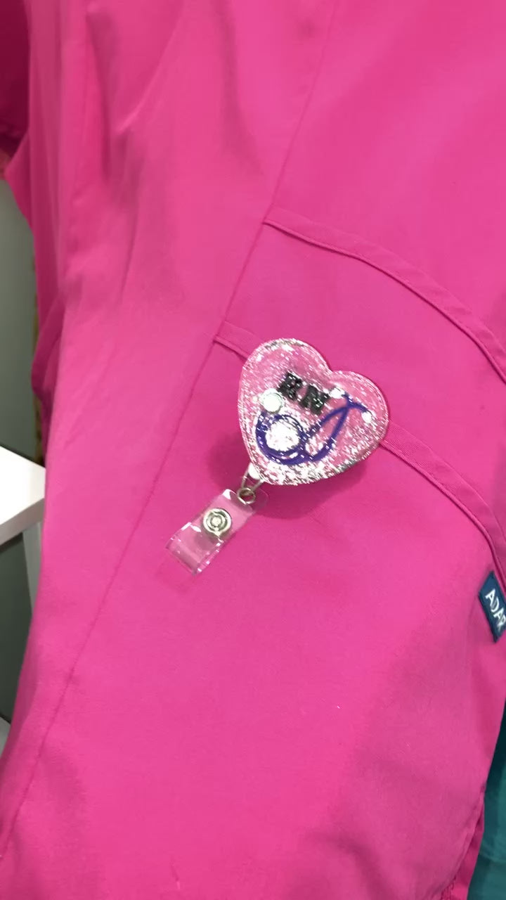 Rn badge reel on a pink scrub shirt.
