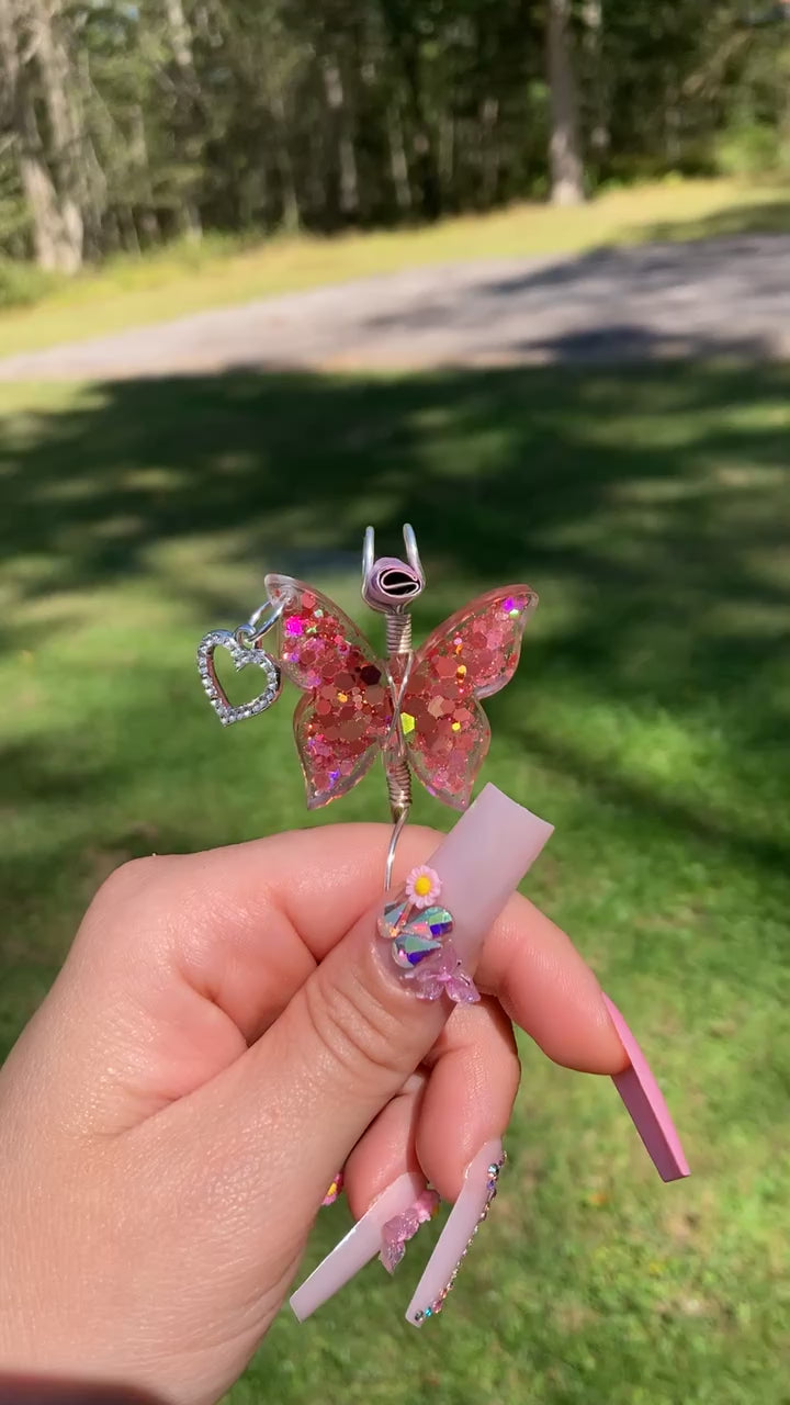 Pink sequin butterfly smoke ring with a faux lit joint in a outdoor setting