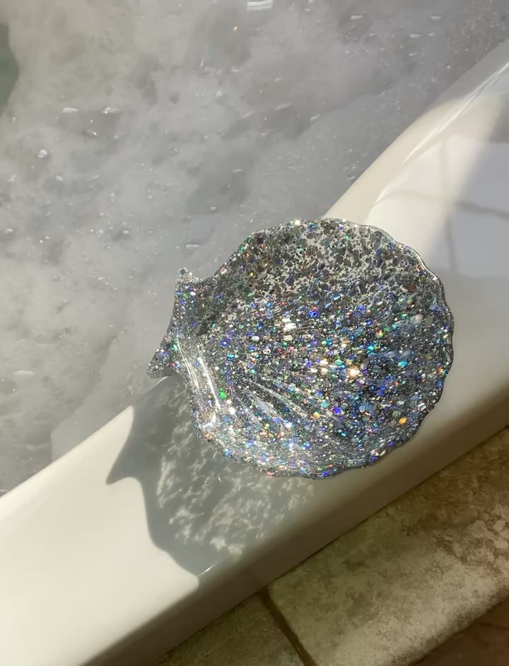 The video shows a seashell shaped soap dish on a bath tub edge.