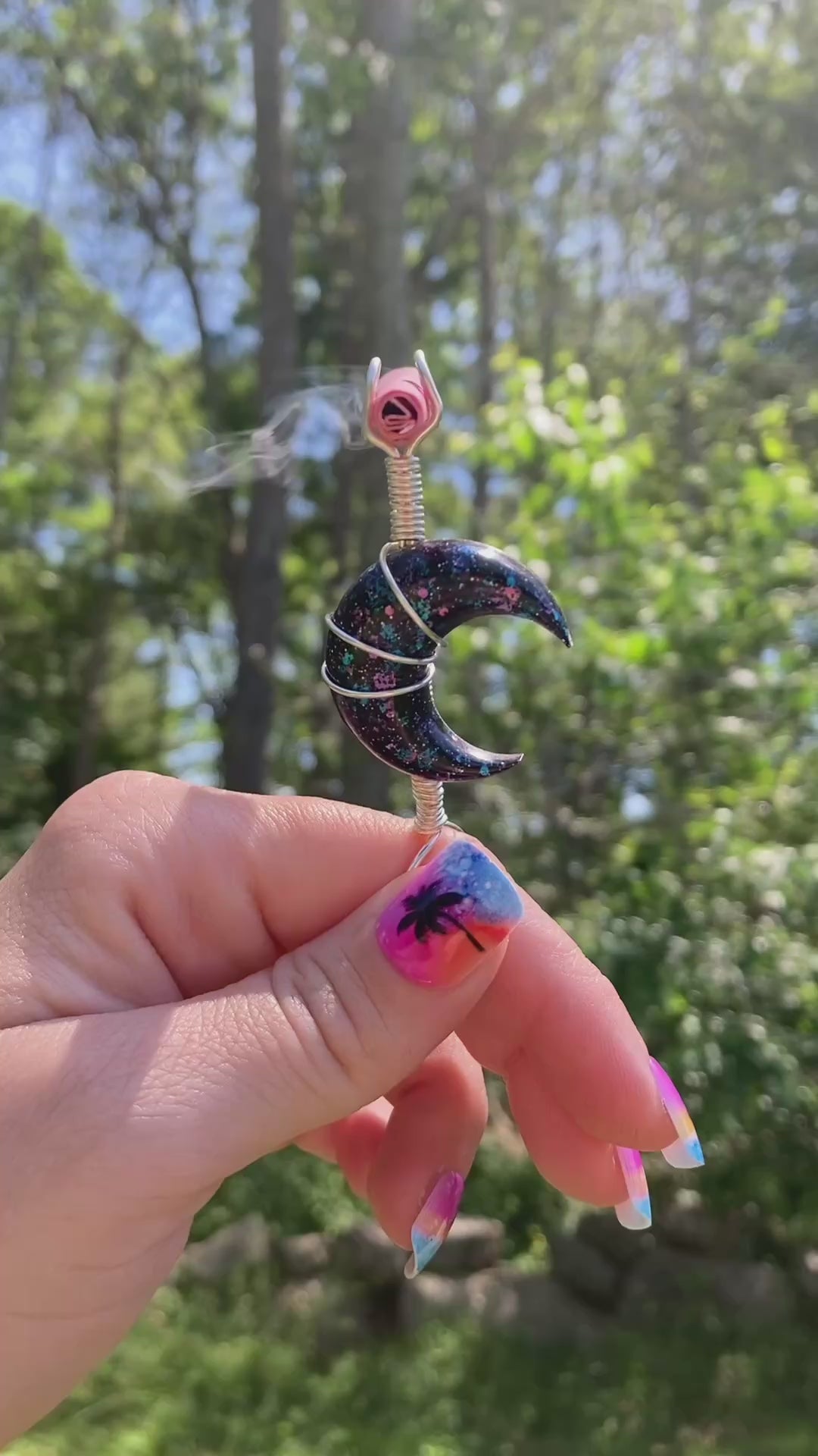 Video shows a black crescent moon smoke ring lit with a faux joint outside 