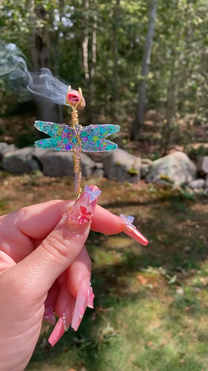 Video shows a dragonfly smoke ring lit with a faux joint in a nature setting.