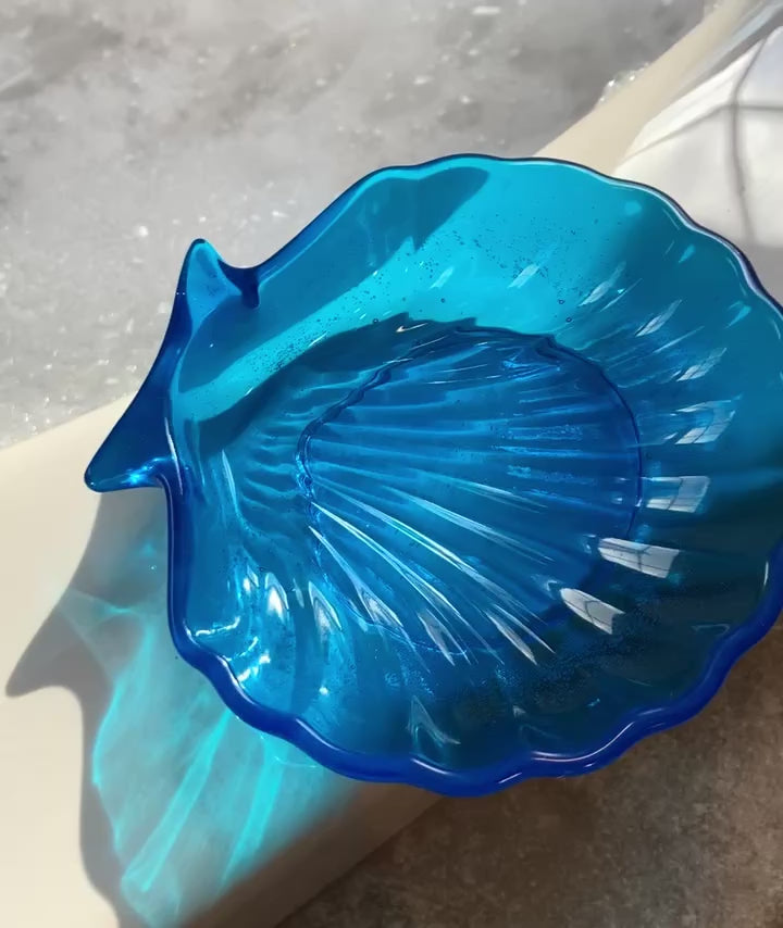 Video shows a blue seashell shaped soap dish on a jacuzzi tub