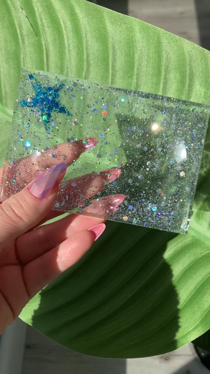 Video shows a starfish soap dish in a manicured hand in a leafy background 